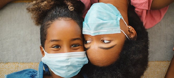 Image of mother and daughter masking together