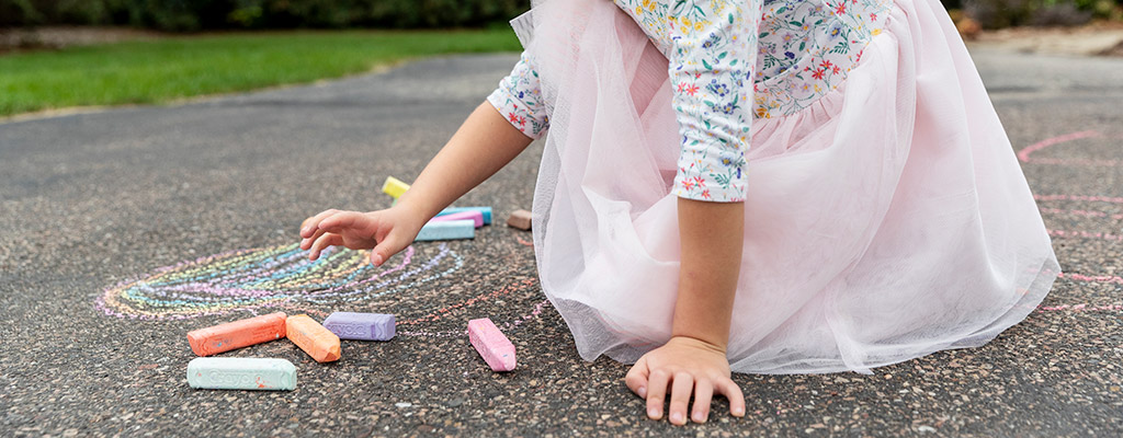 girl drawing with chalk / newsroom hero image / patient stories